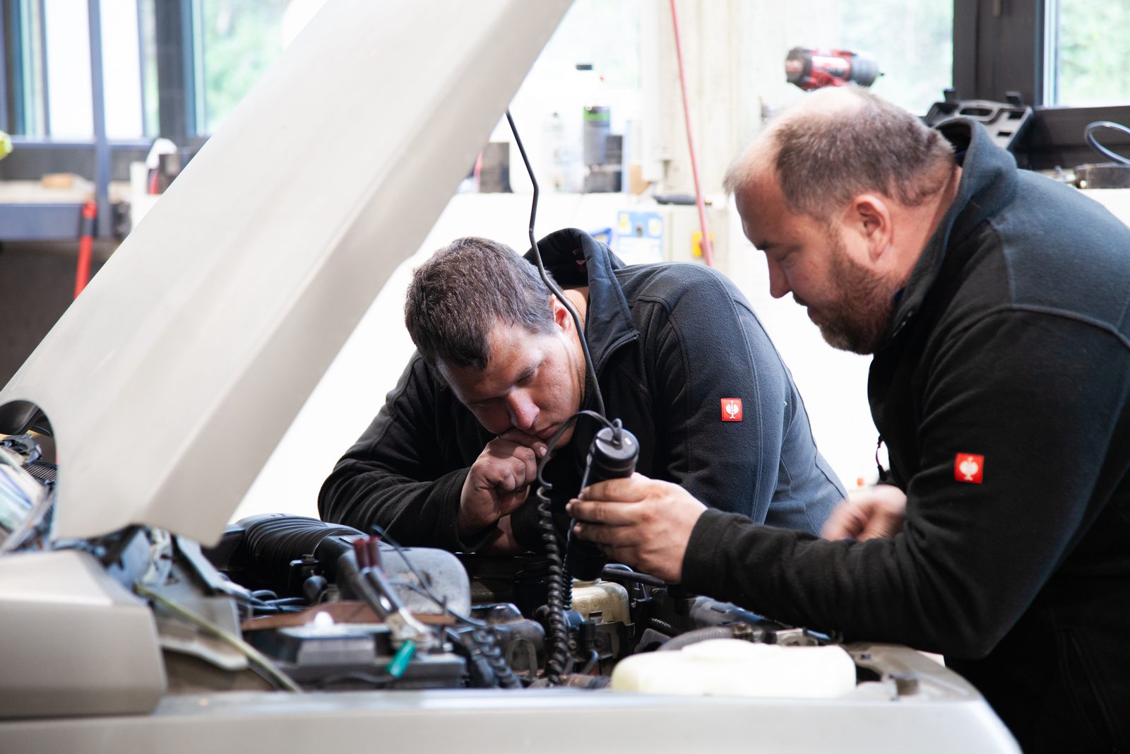 Zwei Mechaniker bei der Fehlersuche im Motorraum